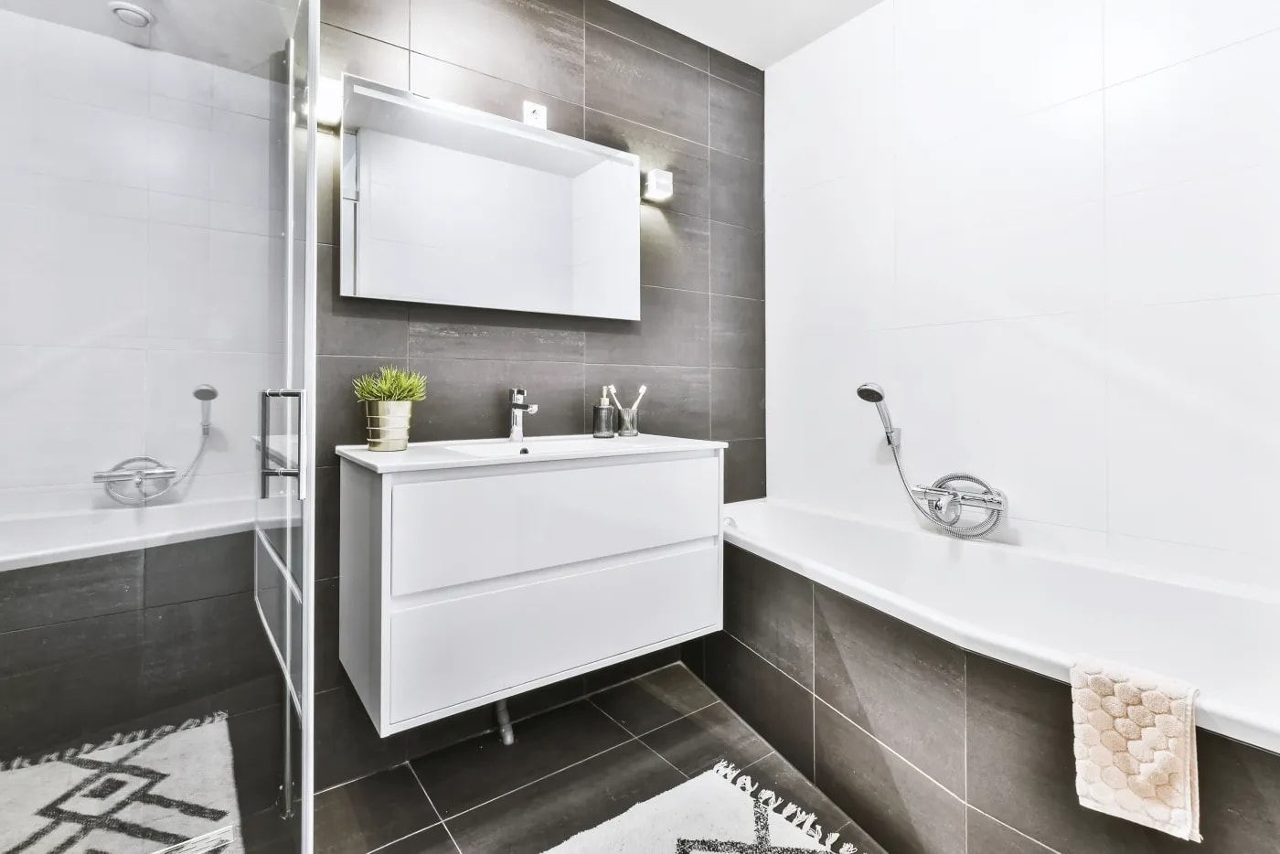Modern black-and-white bathroom with a combined bathtub and shower, a floating vanity cabinet, and a mirrored door