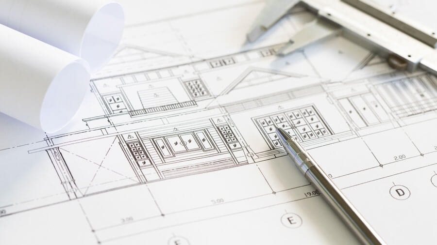 Close-up of a facade elevation drawing with a ballpoint pen and a caliper resting on it.