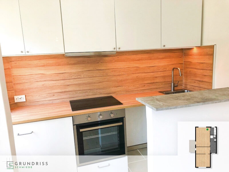 Photo of a modern kitchen with wood-fronted units and a kitchen island, with a small floor plan in the lower right corner highlighting the kitchen area.