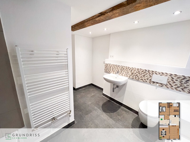 Photo of a ground-floor bathroom with a shower, washbasin and towel radiator on the wall, with a floor plan in the lower right corner highlighting the bathroom area.