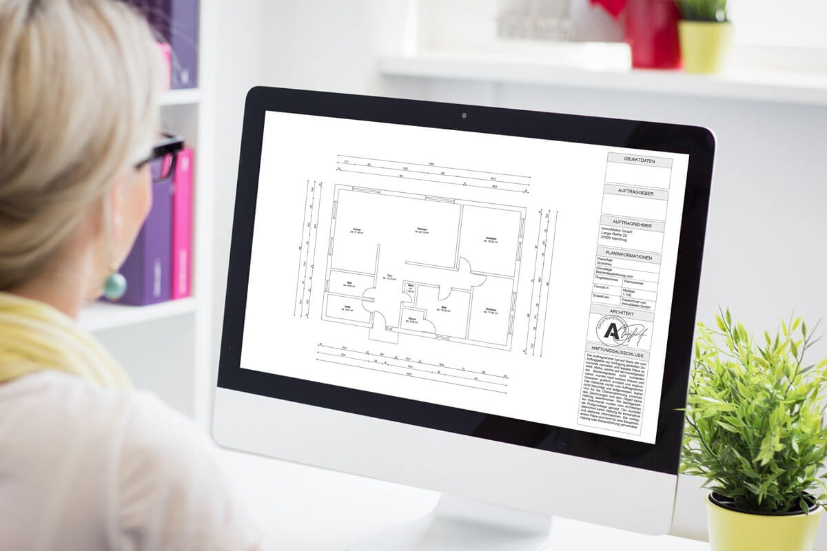 Rear view: a woman sits at her office desk reviewing the dimensioned floor plan of a 6-room apartment on a monitor.
