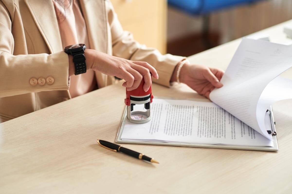 Close-up of a real estate agent stamping a document on a clipboard