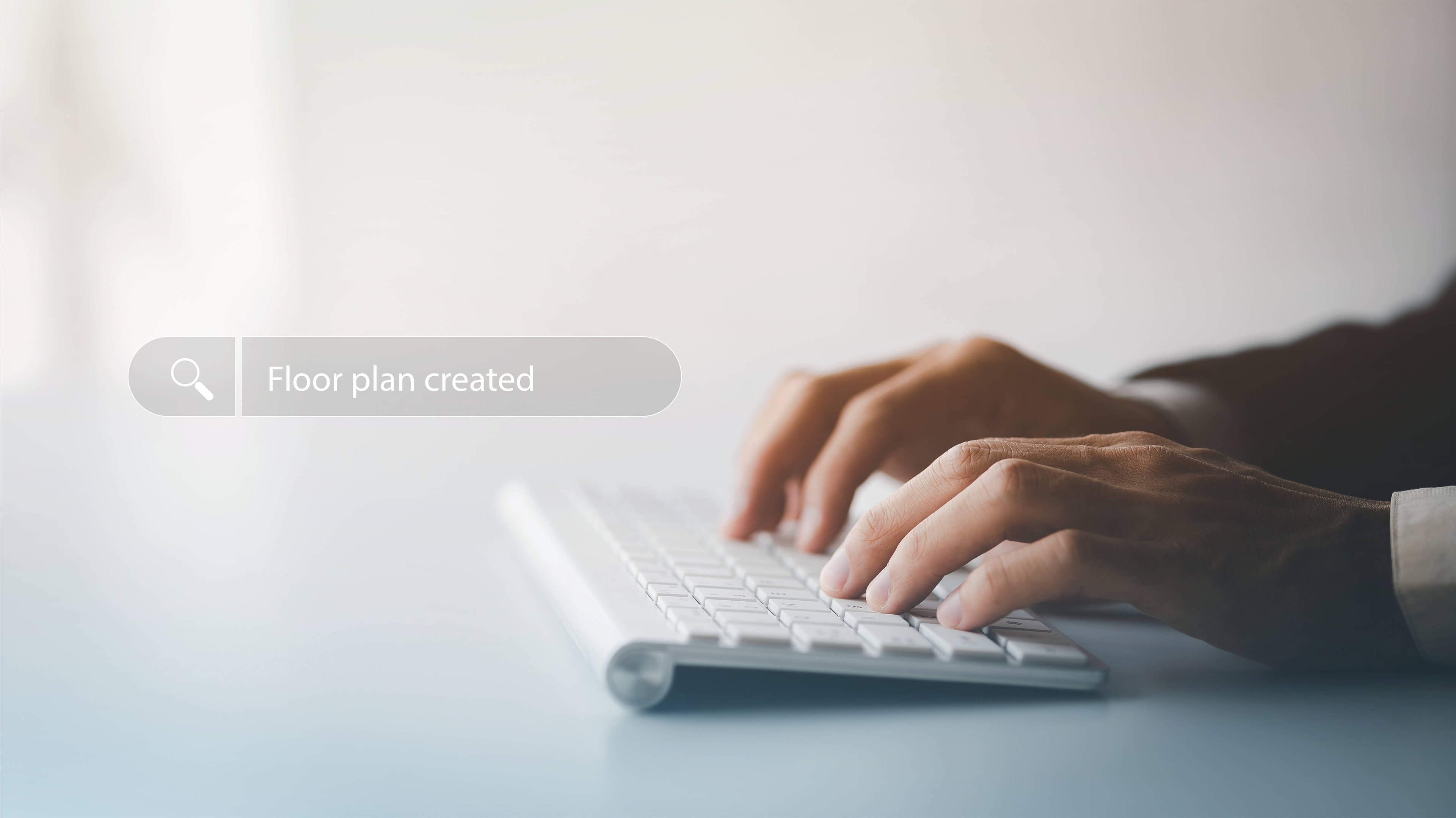 Two hands on a flat keyboard with a virtual search bar hovering above it, in which 'have a floor plan created' is written.