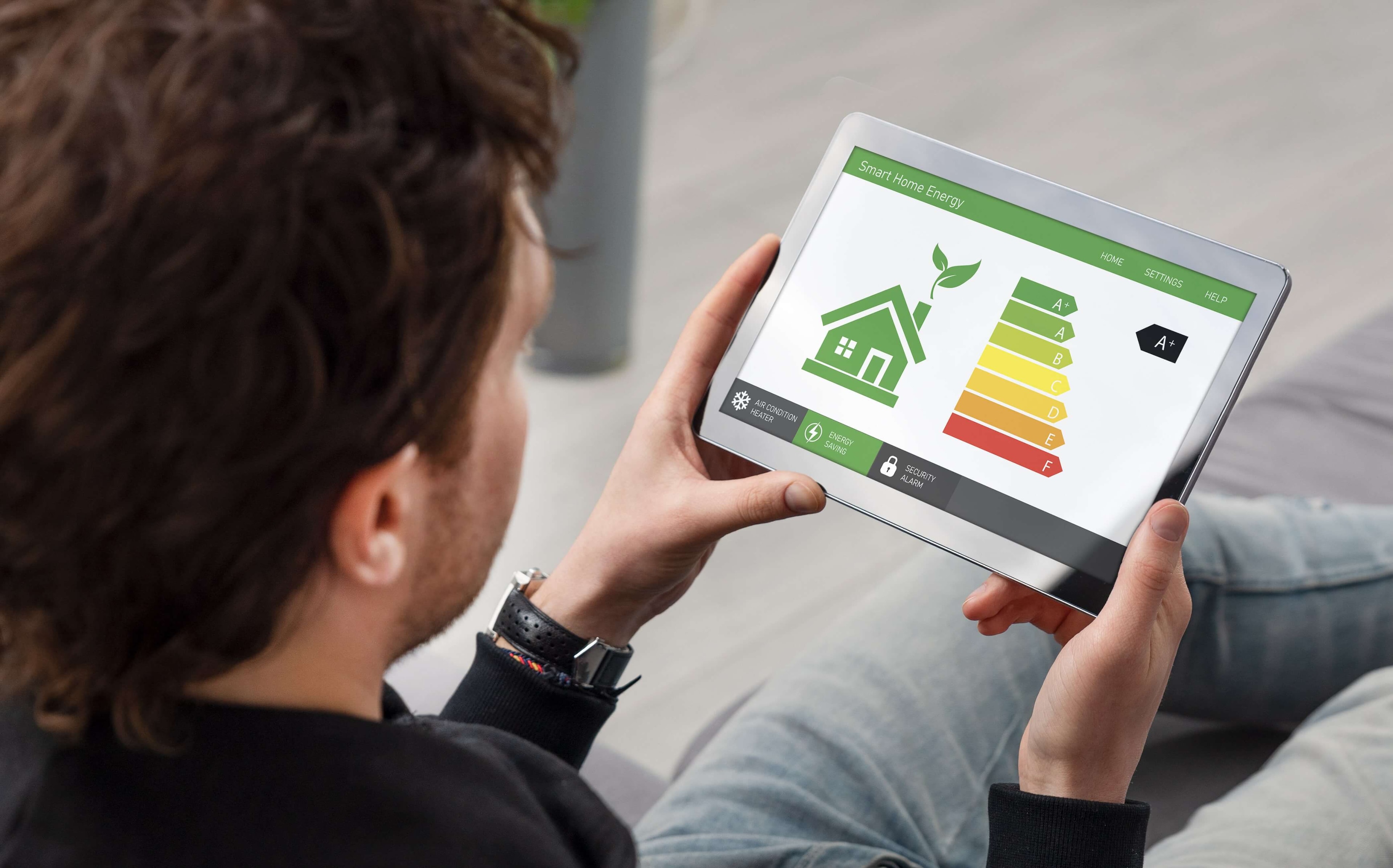 Rear view of a man looking at an energy performance certificate app on a tablet.
