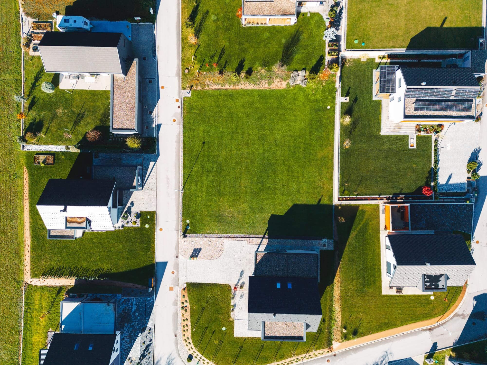 Bird's-eye view of a centrally located plot with an adjoining green space and several neighboring buildings