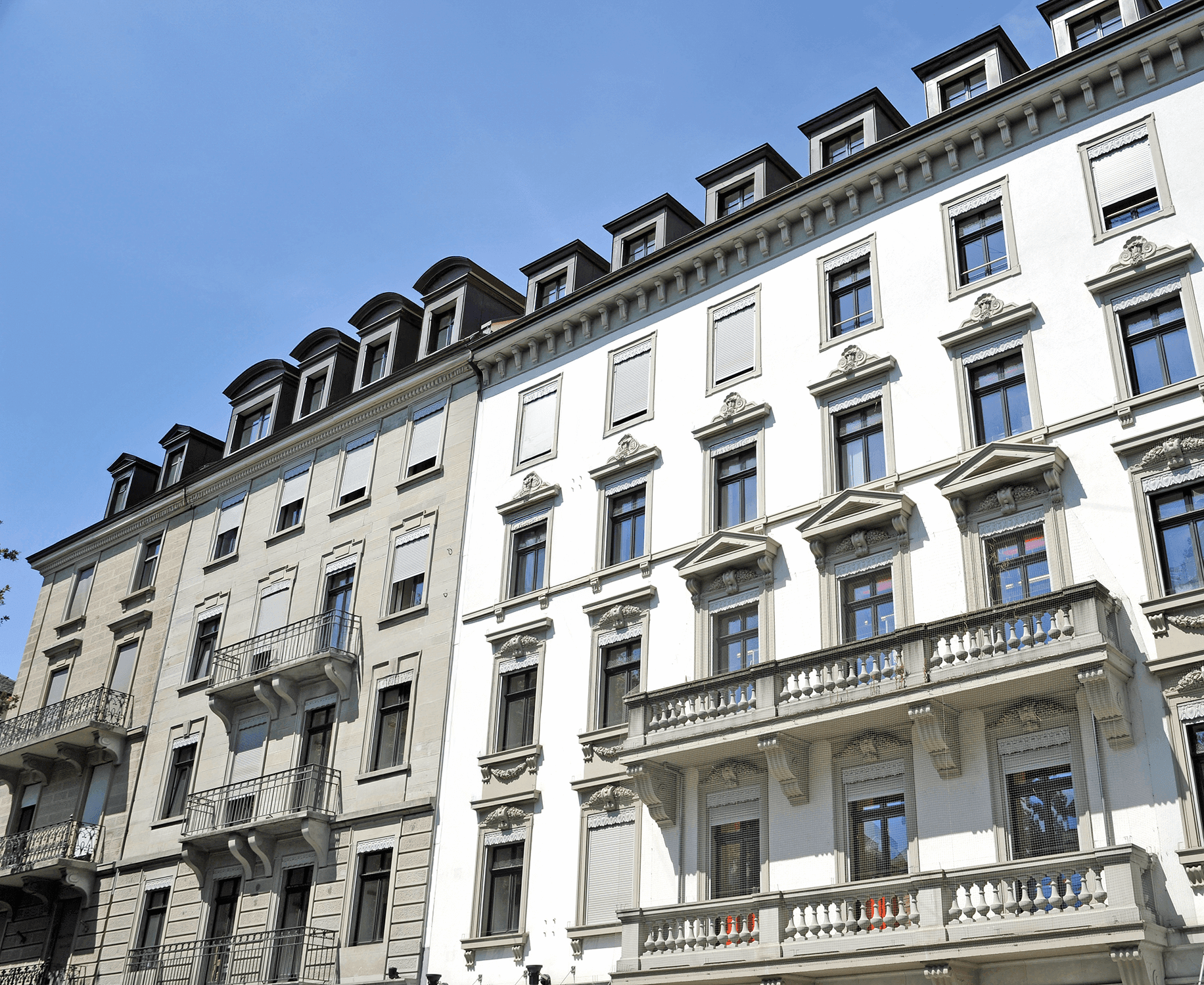 Angled shot from below showing the upper left corner of an urban period-building terraced house with an ornamental facade and balconies