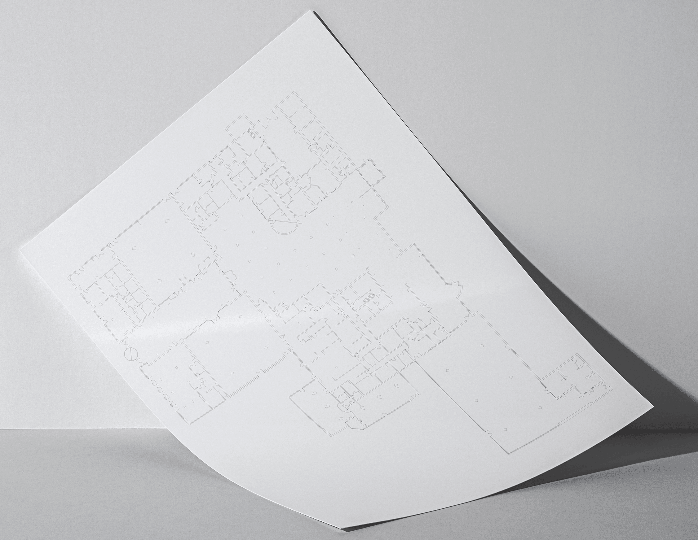 An einer Wand herabgesunkenes Din A4 Papier mit dem Grundriss des Hotels.
