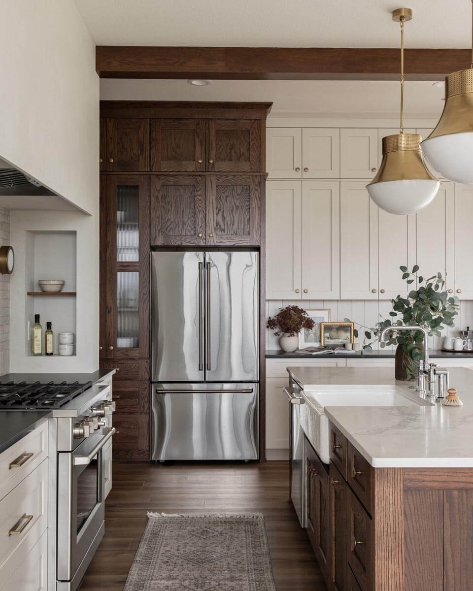 Retro-style kitchen with a mix of light and dark wood, generous cabinets along the front wall, a stove with a wall-width extractor hood on the left and a kitchen island with sink in the centre of the room on the right.