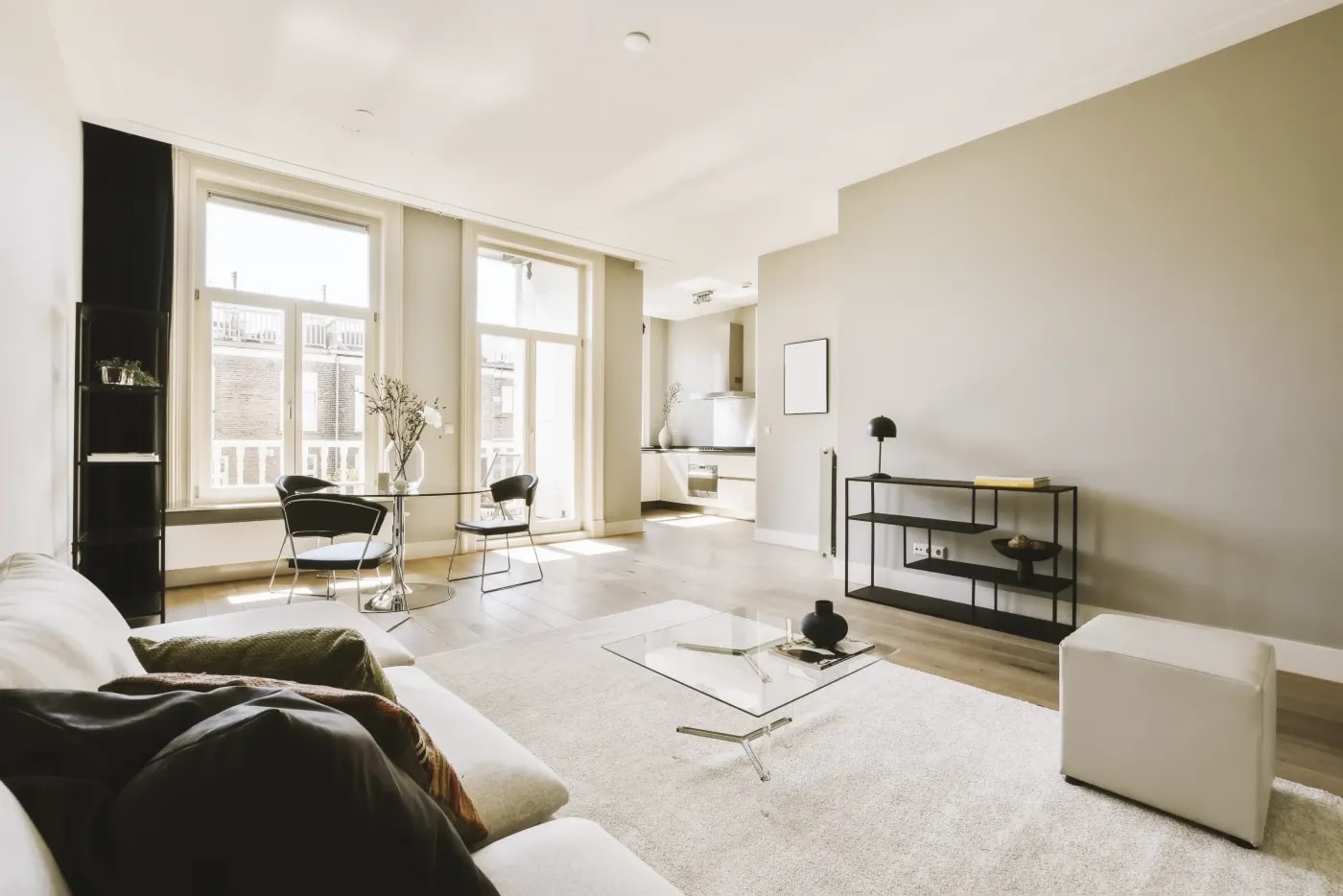A very bright, angular living room in a modern style, connected to an open kitchen in the background.