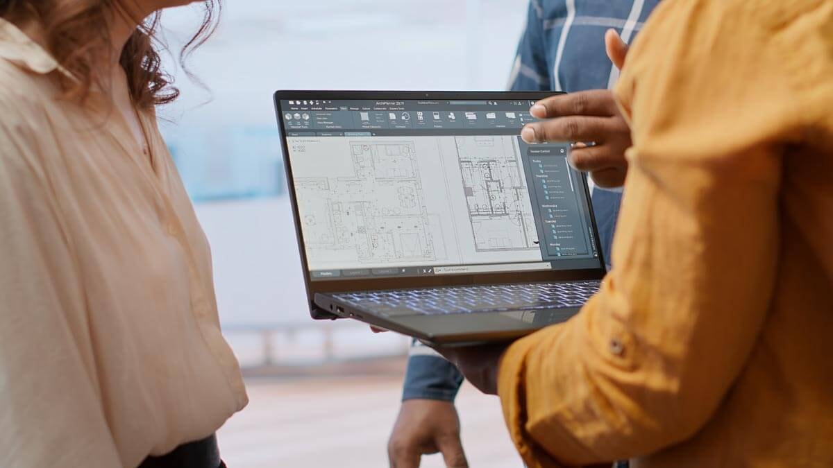 An architect discusses a building plan with clients on a construction site.