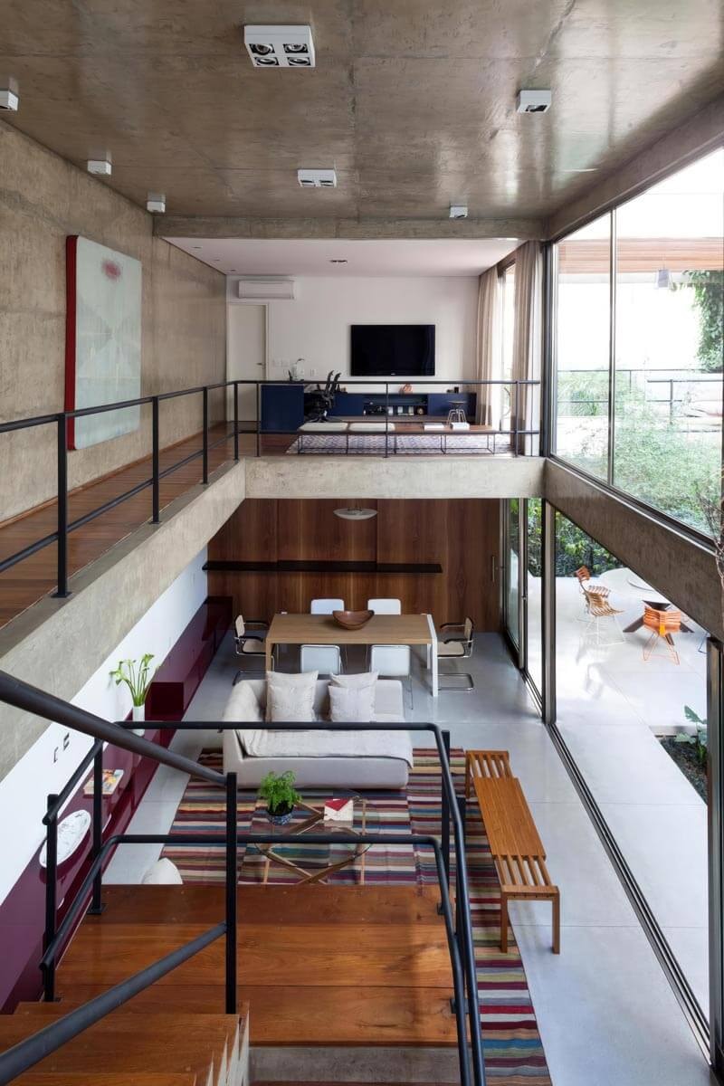 Galeriegeschoss eines modernen Loft in Industrie-Architektur mit Betondecke und Laufsteg neben der Treppe nach unten.