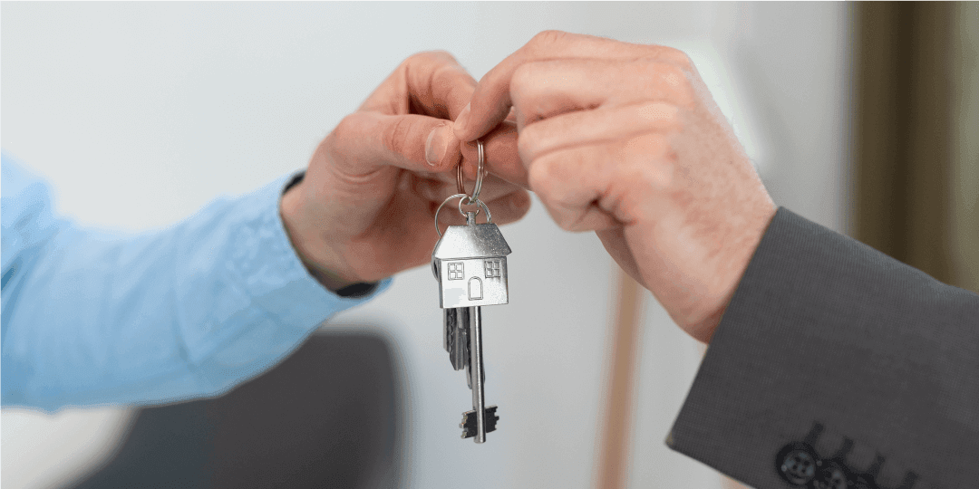 Close-up of a front door key handover