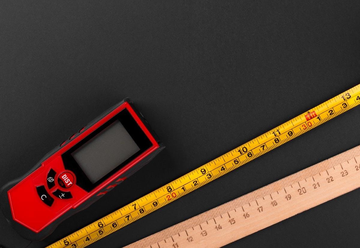 Three different measuring devices – a digital device with a display, a tape measure, and a ruler
