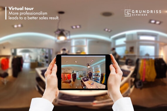 Zwei Hände halten ein Tablet empor auf dem der Teil des Ladens virtuell zu sehen, dessen 360 Grad Bild im Hintergrund zu sehen ist.